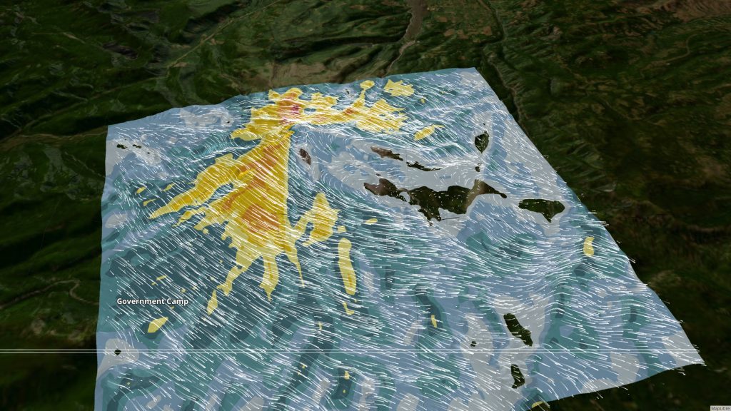 3D rendering of a detailed wind forecast around Mount Hood in northwest Oregon. Wind speeds are shown as white particles flying along a 3D terrain map, swelling to high speeds on the windward side of the mountain and pooling in smaller, slower eddies on the leeward side.